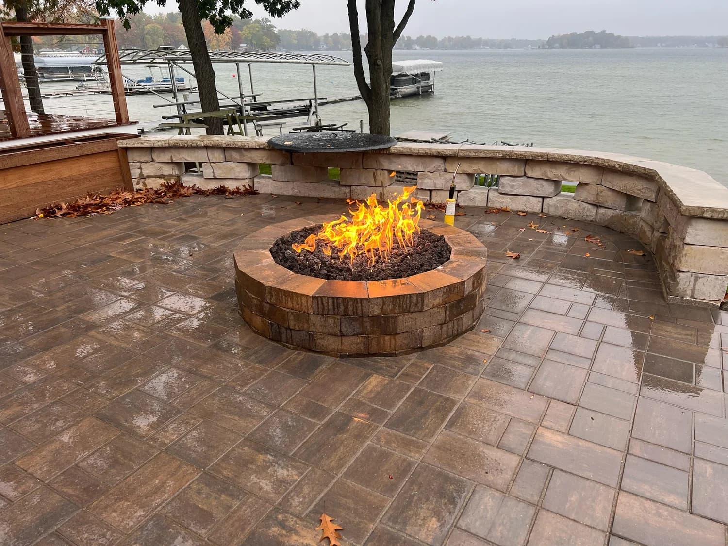 Lakeside stone fire pit with built-in seating wall and lake backdrop